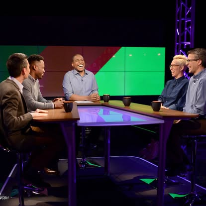 Alex in a studio with 4 other people at a table.