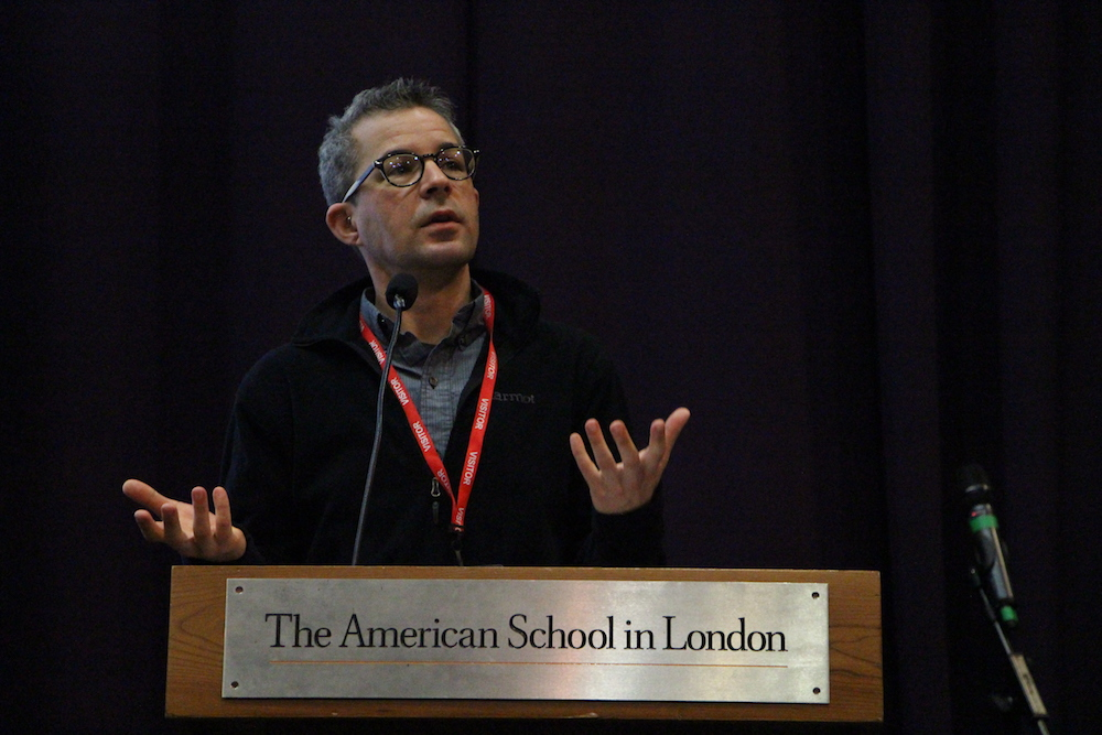 Author Alex Myers at a podium giving a speach to the American School in London
